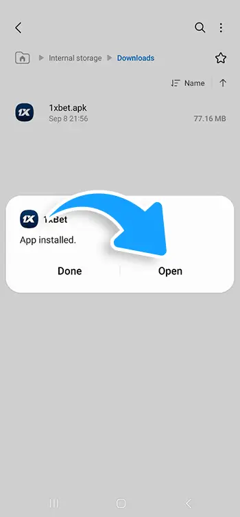 Android file manager screen showing successful 1xBet app installation with a blue arrow pointing to the Open button
